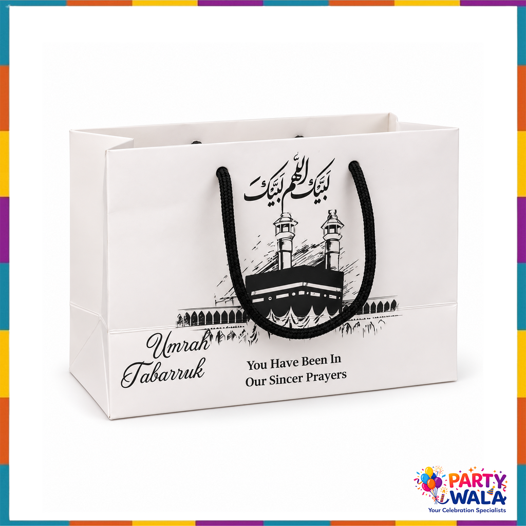 White Umrah Tabarruk gift bag with black braided handles and Kaaba sketch print