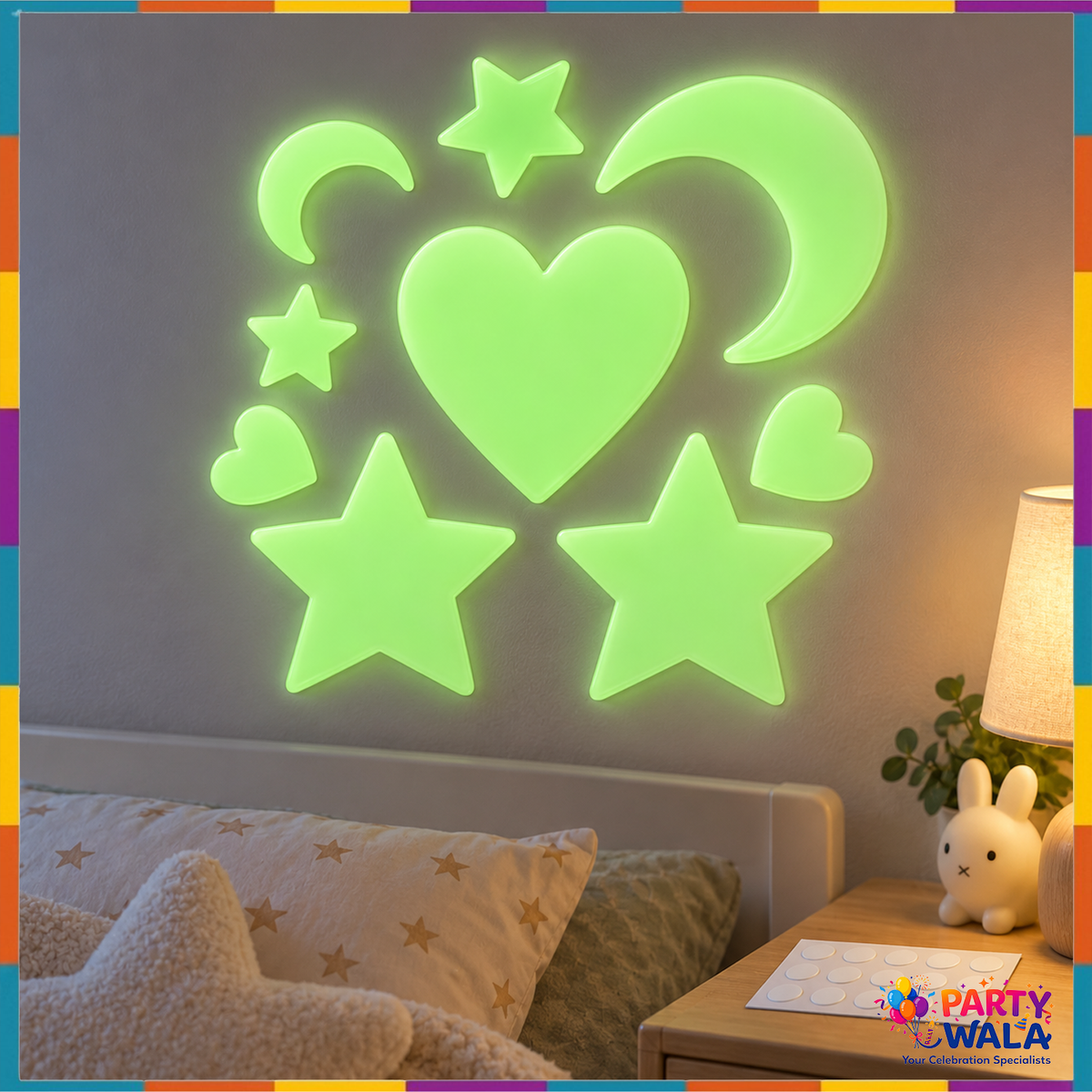 Green moon, stars and hearts arranged on a bedroom wall in a dim room